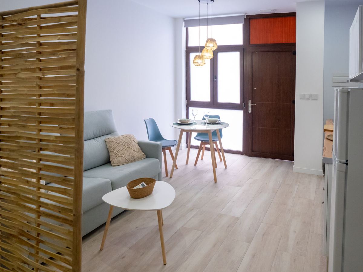 Salón con sofá cama y mesa