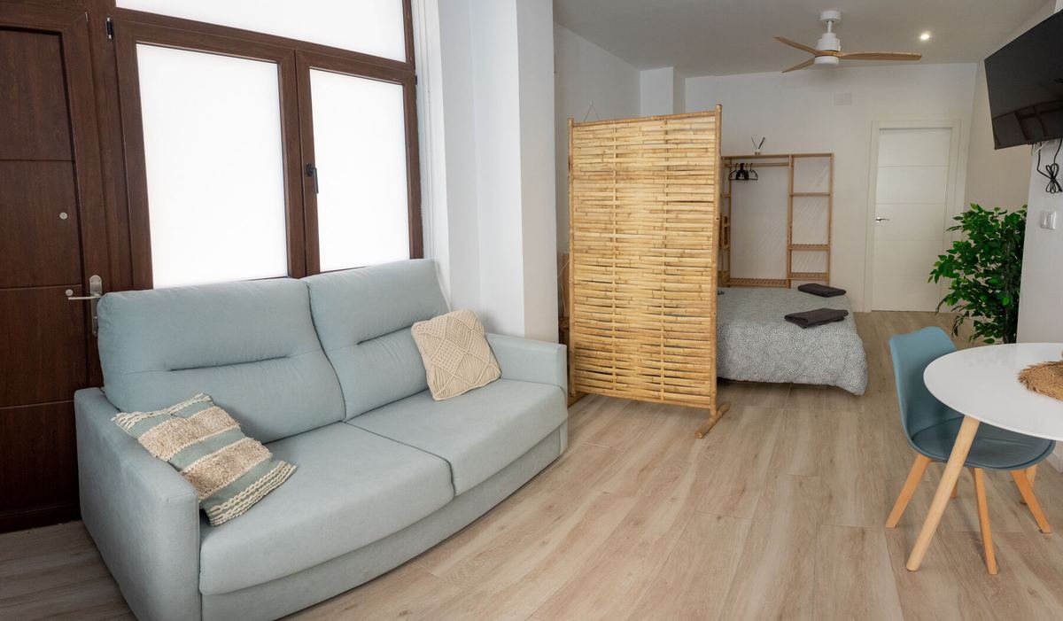 Salón con sofá cama y mesa