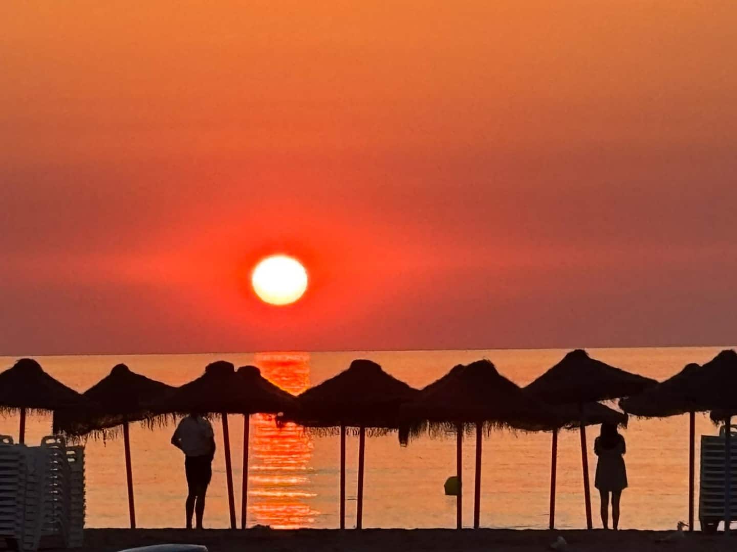 Sombrillas de paja en la playa de la Malvarrosa al amanecer